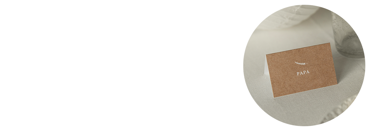 Nahaufnahme einer Tischkarte, schlichtes Design, mit Text "Papa", aufgestellt auf einem gedeckten Tisch