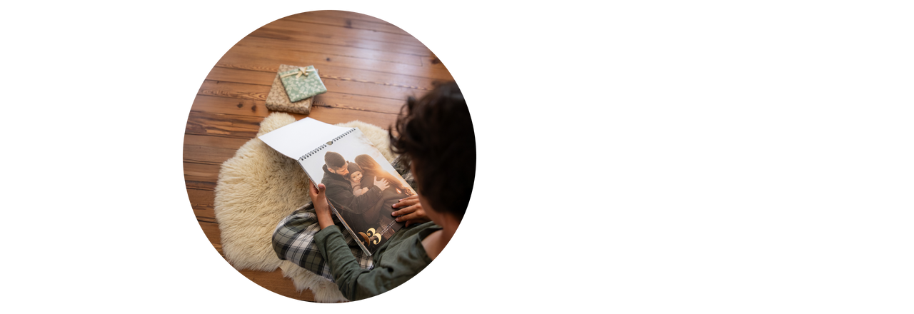 Junge blättert durch einen Fotokalender mit Spiralbindung