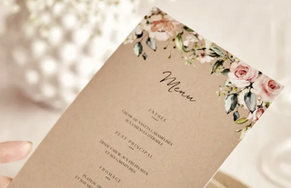 Menükarten in der Hand über dem Hochzeitstisch